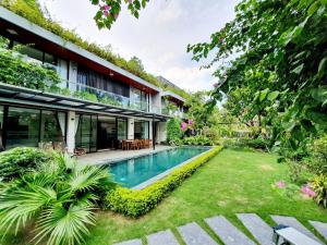 an external view of a house with a swimming pool at FLAMIGO Đại Lải - Villa Tự Doanh in Phúc Yên