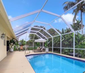 een zwembad met een glazen serre en een zwembadvisor bij Marco Beach House l Private Pool in Marco Island