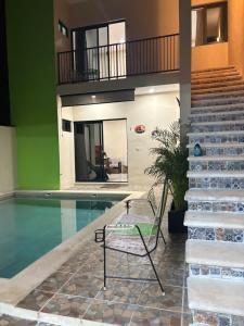 - une piscine avec une chaise à côté d'une maison dans l'établissement Departamentos Misavi, à Pisté 12 autres photos