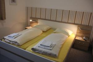 a bed with two pillows on it in a room at Airport-Hotel zum Taubengrund in Kelsterbach