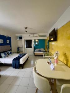 ein Hotelzimmer mit zwei Betten und einem Tisch und einem Bett in der Unterkunft Brisa Marina Suites - Atras de Playa regatas y Malecon in Veracruz