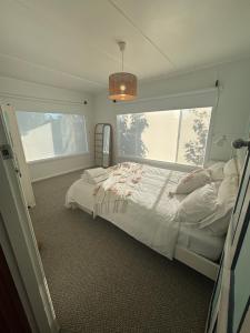 a bedroom with a bed and a large window at Port Sorell Beach Shack in Port Sorell