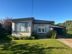 a small house with a lawn in front of it at Port Sorell Beach Shack in Port Sorell