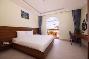 a bedroom with a bed and a desk and a window at Hồng Chúc Hotel in Phú Quốc +105 photos