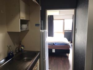 a small kitchen with a sink and a bed at LEGALCOURT - Vacation STAY 14717 in Akiruno +28 photos