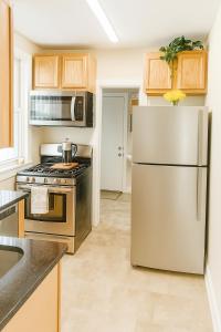 Una cocina con refrigerador y gabinetes de acero inoxidable. en Near Stadiums and Downtown in Peaceful Neighborhood, en Baltimore