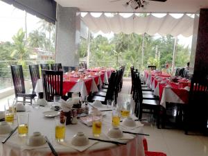 a long table with red and white tables and chairs at 1001 Nights Hotel in Mui Ne