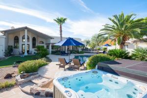 a backyard with a hot tub and a house at Luxury Mountain Estate-Pool-Spa-BBQ+Bar-Fire pit in Scottsdale