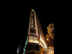 een hoog gebouw met 's nachts verlichting bij Stanford Hillview Hotel Hong Kong in Hong Kong