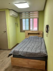 un dormitorio con una cama y una ventana en 전북대근처 시외버스터미널 원룸6, en Haga-ri