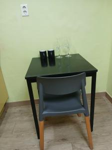 Una mesa negra con una silla y dos copas de vino en 전북대근처 시외버스터미널 원룸6, en Haga-ri