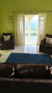 un salon avec un canapé et une grande fenêtre dans l'établissement Ocean Heights, à Arnos Vale