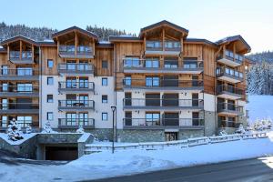 ein großes Apartmenthaus mit Schnee auf dem Boden in der Unterkunft New Ideal 2 rooms 12 4 people in Saint-Bon-Tarentaise