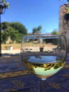 un bicchiere di vino bianco seduto su un tavolo di Le Grenier 1 Rue Verte Tusson 16140 France a Tusson