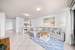 een woonkamer met een bank en een tafel bij Chambers River Retreat in Maroochydore