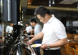 un hombre está sosteniendo un plato de comida en Au Viet Hotel en Hanói