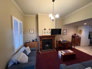 a living room with a blue couch and a fireplace at Barnard street Cottage in Bendigo