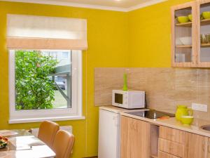 a kitchen with yellow walls and a white microwave at Neliusi in Ventspils