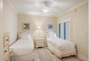 two beds in a bedroom with a ceiling fan at WS5123: 5123 Windswept in Kiawah Island