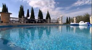 a large pool of water with people sitting in chairs at Château des Fontaines in Canet d'Aude