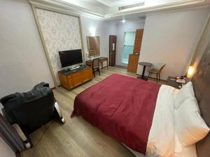 高雄花乡旅馆連鎖-凤山店的配有床和电视的酒店房间