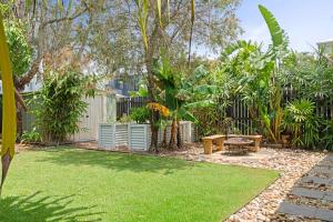 a garden with a bench and a fence at The Palma your Leafy Tropical Escape in Moffat Beach in Caloundra