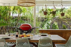 a patio with a table and a grill at The Palma your Leafy Tropical Escape in Moffat Beach in Caloundra +38 photos