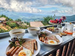 a table with plates of breakfast food on a balcony at ดานบนดินCamping in Ban Thung Phan Ha