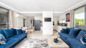 sala de estar con sofás azules y cocina en 4-102 Magnus Street, en Nelson Bay