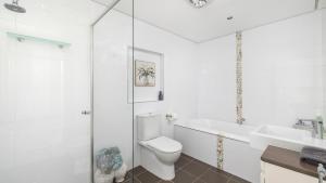 Un baño blanco con inodoro y lavabo. en 4-102 Magnus Street, en Nelson Bay 18 fotos más