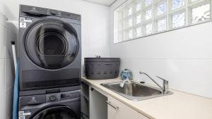 una cocina con lavadora y fregadero en 4-102 Magnus Street, en Nelson Bay