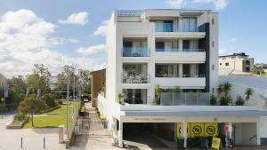 un edificio de apartamentos blanco con aparcamiento en 4-102 Magnus Street, en Nelson Bay