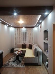 una sala de estar con un sofá y una mesa en Perisic Lux Apartman Obrenovac, sa parkingom, en Obrenovac