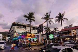 una concurrida calle de la ciudad con coches y palmeras en Sweett Lemon Home, en Patong Beach