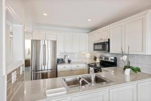 a kitchen with white cabinets and stainless steel appliances at BMV1903: 1903 Bohicket Marina Villa in Seabrook Island