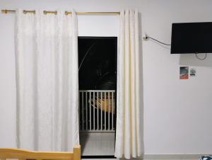 ein Zimmer mit einem Fenster und einem weißen Vorhang in der Unterkunft Hosteria La Veleta, Playas in Playas