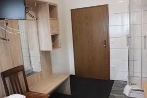 baño pequeño con puerta de madera y aseo en Airport-Hotel zum Taubengrund en Kelsterbach