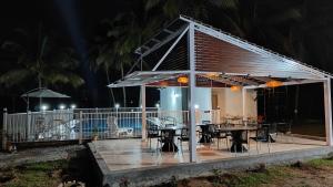 a pavilion with tables and chairs on a deck at night at Encanto Farmstay Resort in Mysore