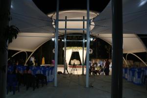 a white tent with people sitting under it at night at Encanto Farmstay Resort in Mysore +54 photos