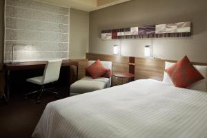 Una habitación de hotel con una cama, un escritorio y una silla. en Mitsui Garden Hotel Sapporo, en Sapporo