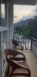 2 rieten stoelen op een balkon met uitzicht bij NAT City Ella in Ella