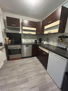 eine Küche mit dunkelbraunen Schränken und Geräten in der Unterkunft MelsHome Entire apartment to feel good in Geislingen an der Steige