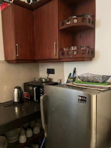 a kitchen with a stainless steel refrigerator and wooden cabinets at The Budget White House Hotel in Nuwara Eliya +16 photos
