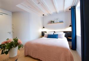 a bedroom with a bed and a vase with flowers at Victoire & Germain in Paris
