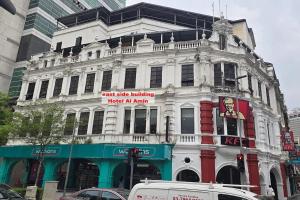 a white building with a sign on the front of it at Hotel AL Amin in Kuala Lumpur