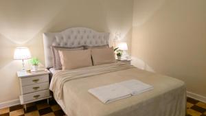 ペトロポリスにあるPalácio Quitandinha Espetacular Apartamento com Vista para o Lagoのベッドとタオル2枚のある寝室