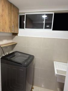 a bathroom with a trash can and a window at apartamento M&C in San Gil