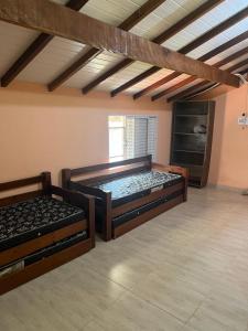 2 Betten in einem großen Zimmer mit einer Decke in der Unterkunft Sarau's Beach House Boracéia in Boracéia