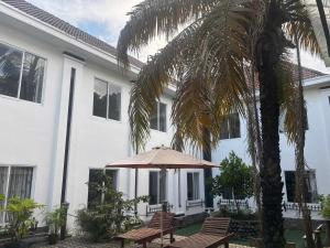 a white building with a table and an umbrella at Hoang Cung Hotel in Ấp Phú Thọ