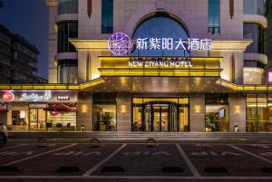 a building with a newinning night sign on it at Fuzhou Xin Zi Yang Hotel in Fuzhou